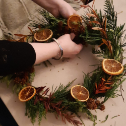 Someone's hands making a wreath
