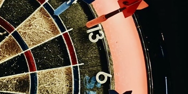 a partial view of a dart board showing 3 darts played onto the board.