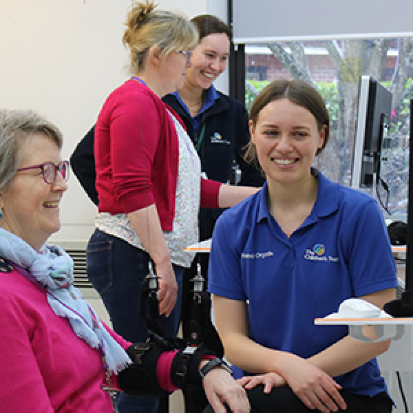 Image containing a picture of staff demonstrating neurotech to visitors at the 2024 Neurorehabilitation showcase