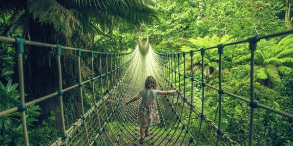 Girl walking on rope bridge