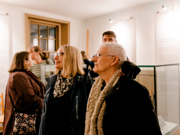 a group in winter clothes admire a museum room