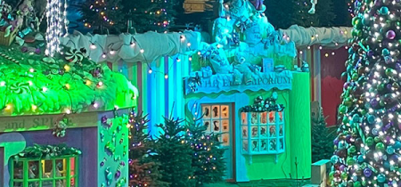 photo shows Santa on a tractor with three elves. There is snow on the tractor.