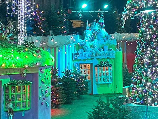 photo shows Santa on a tractor with three elves. There is snow on the tractor.