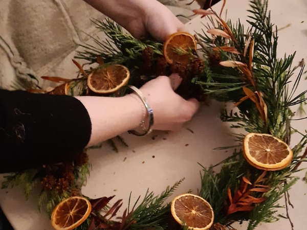 Someone's hands making a wreath