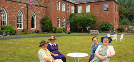 Four ladies in 1940s costume sitting in the grounds of Hartlebury Castle