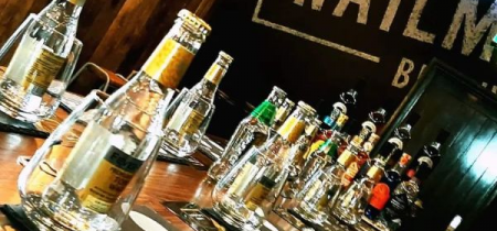 A wooden table with a selection of gins and glasses on