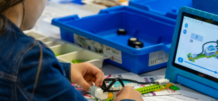 Child coding a lego vehicle to move as part of a IzWiz Robotics Workshop