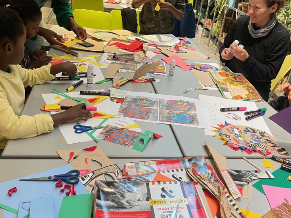 Families around a table cutting and sticking coloured paper crafts
