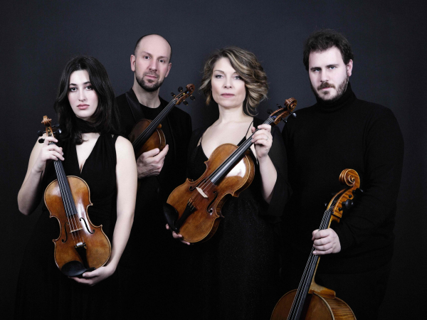 Four people dressed all in black, holding string instruments