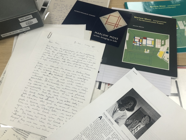 Archival documents and papers from the Women's Art Library scattered across a table.