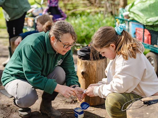 A staff member helping a child at our forest school