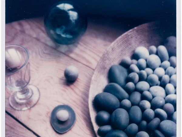 A photographic artwork of a table in the Kettle's Yard house, with a bowl of pebbles and a glass goblet.