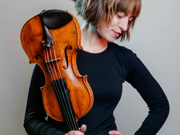 A woman with a short bob haircut holding a violin