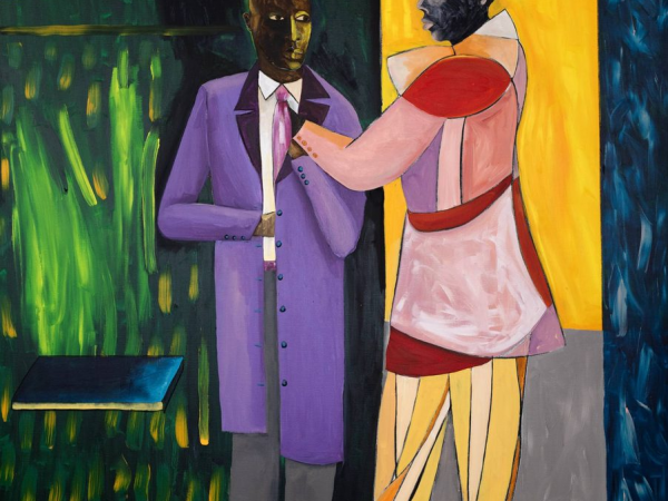 Two men standing in front of a shop in brightly coloured clothing.