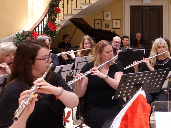 A concert band performing in a festively decorated Great Hall