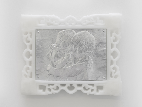 An embossed or engraved metal print of two children hugging, in a decorative white frame.