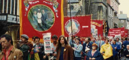 Archive photograph of a banner march with lots of different red mining banners