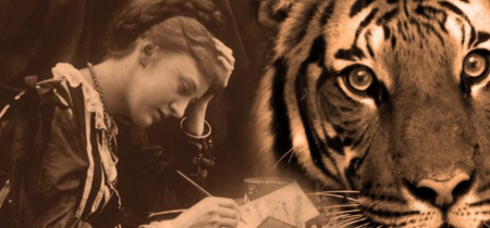 Woman writing at a desk with a tiger in front of her.