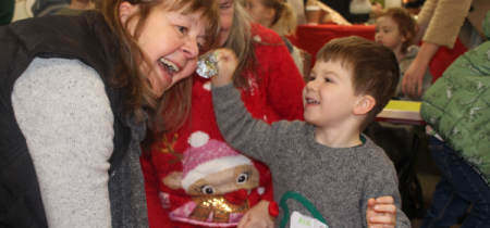 a child putting a bauble on an adult