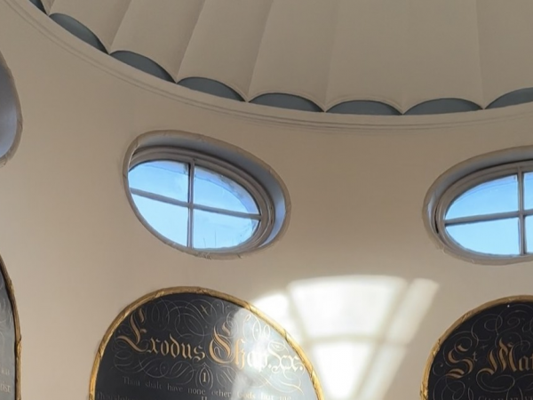 Image of the Chapel interior, featuring windows and transcriptions on the wall.