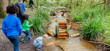 children walking along the nature trail stream