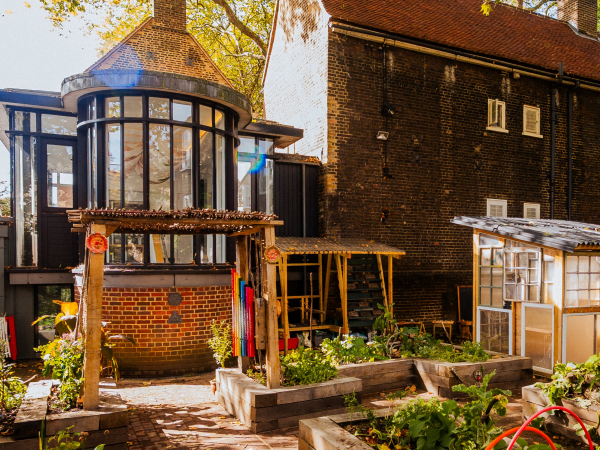 View of a garden, including a greenhouse and trellis and paths