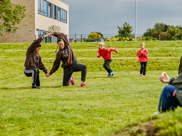 Two people performing a dance routine on a large playing field.