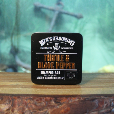 Thistle and black pepper scented shampoo bar in black tin