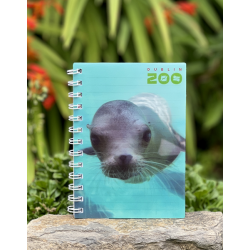 a spiral bound notebook with a cover displaying the dublin zoo name and a photo of a sealion under water.